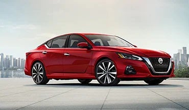 2023 Nissan Altima in red with city in background illustrating last year's 2022 model in Cronic Nissan in Griffin GA